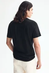 Remera de algodón liviano color negro, con cuello redondo y mangas cortas, de corte entallado.