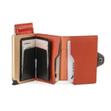 Billetera minimalista de cuero color beige con detalle superior en color ladrillo. Cuenta con un compartimento para tarjetas con mecanismo de expulsión y protección RFID.