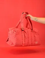 Bolso tipo tote color beige con diseño acolchado y doble asa de hombro.