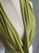 Conjunto de dos piezas color verde oliva, compuesto por un top con escote profundo y diseño cruzado, y una falda midi ajustada de tiro alto.