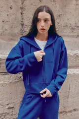Pantalón flare de tiro medio, color azul, confeccionado en tejido de punto elástico. Cuenta con cintura elástica ajustable con cordón, bolsillos delanteros y corte amplio en las piernas.