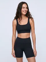 Top deportivo negro con escote redondo y detalle de malla en el centro del pecho, de diseño ajustado y tirantes anchos.
