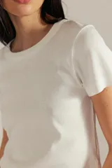 Remera de algodón acanalado color marrón topo, de calce entallado, con escote redondo, mangas cortas y efecto desgastado en las costuras.