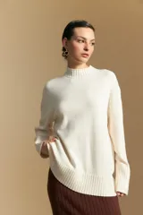 Polera de cuello alto confeccionada en tejido de punto negro, con diseño de textura acanalada en cuello, puños y ruedo, y trama vertical en mangas y espalda.