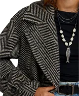 Abrigo tipo peacoat con diseño oversize y patrón de espiga. Presenta cuello clásico, cierre frontal de doble botonadura y silueta estructurada.