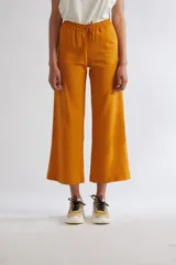Pantalón mostaza de corte wide leg y largo midi, con cintura elástica fruncida y cordón ajustable.