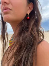 Par de aros dorados con dije colgante de cereza roja.