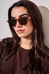 Lentes de sol polarizados con armazón redondo de acetato en color marrón lavado y micas oscuras.
