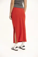 Falda midi de punto color rojo, corte ajustado y cintura alta.
