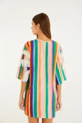 Vestido corto estilo remerón de algodón, con estampado de rayas verticales multicolor y grandes hojas tropicales en el frente. Tiene cuello redondo, hombros caídos y mangas amplias hasta el codo.