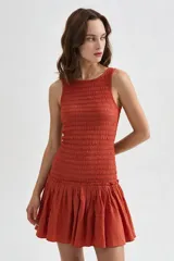 Vestido corto beige sin mangas con cuerpo de nido de abeja elástico y falda corta acampanada con vuelo.