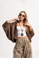 Chaqueta tipo bomber de tela gamuzada color marrón, con diseño oversize, mangas amplias tipo murciélago y cuello camisero.