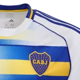 Camiseta de fútbol Adidas del Boca Juniors, correspondiente al tercer uniforme. Diseño de fondo blanco con franjas horizontales degradadas en azul y amarillo, cuello redondo y mangas cortas. Incorpora tecnología AEROREADY.