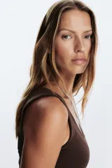 Camiseta blanca ajustada de poliamida con tirantes anchos y escote redondo.