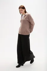 Sweater de punto color azul, con cuello polo y escote en V, de manga larga y diseño holgado.