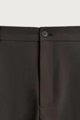Pantalón relaxed fit marrón oscuro, de corte ancho y recto, con pliegues frontales, bolsillos laterales y cierre con botón y cremallera.