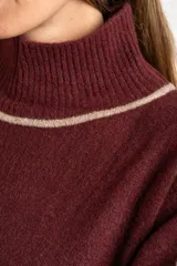 Polera de punto con calce oversize, cuello alto y mangas largas. Presenta un diseño en color negro con franjas laterales en las mangas y detalle en el cuello en tono bronce con acabado brillante.