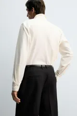 Camisa de corte regular fit confeccionada en una mezcla de algodón y lana. Presenta cuello solapa, manga larga con puños abotonados y cierre frontal con botonadura.