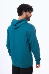 Buzo tipo canguro con capucha y cordones ajustables, confeccionado en felpa color beige. Presenta un pequeño logo bordado en el pecho y una etiqueta decorativa en el puño de la manga.