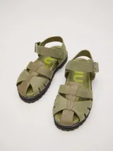 Sandalias tipo romanas de cuero vacuno color beige, con diseño de tiras entrelazadas, hebilla metálica lateral y plataforma de goma dentada.