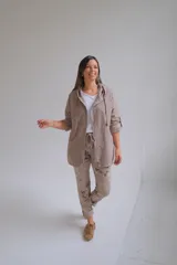 Campera tipo parka liviana color visón, con cierre frontal, capucha con cordones ajustables y mangas 3/4 con detalle de trabilla. Presenta un diseño holgado y casual.