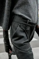 Pantalón de tiro medio con pinzas delanteras y pernera recta. Cuenta con bolsillos frontales, falsos bolsillos traseros de vivo y cierre frontal con cremallera, botón interior y ganchos.
