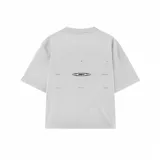 Remera blanca de corte oversize con diseño gráfico estampado en la espalda que incluye texto y un logo central.