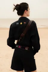 Camisa azul marino de lino con botones, mangas largas y bordados de caballito, sol y la bandera de Uruguay.