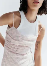 Vestido midi de corte entallado con estampado de cuadros vichy en tonos rosados. Presenta escote cuadrado, tirantes finos y cierre de cremallera invisible en el lateral.