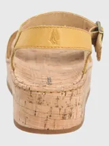 Sandalias Hush Puppies modelo Zug de cuero color amarillo, con plataforma de corcho, tira frontal ancha y tira al tobillo con cierre de hebilla metálica.
