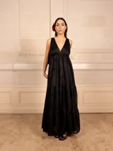 Vestido largo color marrón con bordados florales a tono, escote en V y corte imperio. Tiene falda amplia con volados y breteles finos.