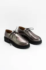 Zapatos tipo wallabee de cuero metalizado en tono peltre, con cordones negros y suela track de goma negra con plataforma.