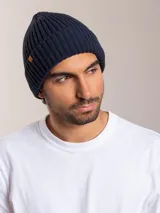 Gorro de lana marrón con diseño de punto canalé y etiqueta de cuero con logo en el lateral.