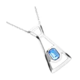 Collar largo de aleación de metales con baño de plata, compuesto por una cadena fina y un dije geométrico de diseño calado con un cristal facetado azul en el centro.