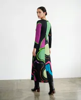 Vestido largo de corte fluido con escote en V y mangas largas. Presenta una estampa exclusiva con diseño orgánico de líneas abstractas en colores vibrantes sobre base negra.