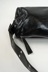 Cartera de hombro color negro con acabado brillante, diseño rectangular y correa ajustable con detalles metálicos.
