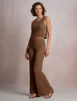 Pantalón de tiro alto con tejido calado y textura labrada, de corte recto con apertura acampanada hacia el ruedo. Cuenta con cintura elastizada y cordón de ajuste con terminaciones de caracoles decorativos.