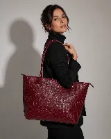 Cartera tipo tote bag de cuero vacuno color marrón oscuro, de diseño estructurado con asas largas para llevar al hombro y cierre superior. Presenta detalles de costuras decorativas y pespuntes en el frente.