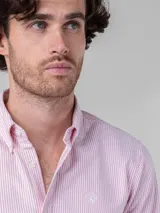 Camisa celeste de corte clásico, con cuello abotonado, manga larga y logo bordado en el pecho.