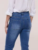 Jean slim skinny de tiro medio en denim azul con proceso de lavado, calce ajustado y largo al tobillo. Cuenta con pretina con presillas, bolsillos delanteros y traseros, y acceso frontal con botón y cierre.