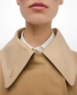 Gabardina larga color tostado con doble solapa y cierre cruzado con doble botonadura. Cuenta con manga larga, bolsillos verticales de vivo en el delantero y trabillas en los puños.