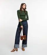 Blusa de punto de manga larga con cuello bote y textura acanalada vertical. Presenta un diseño ajustado al cuerpo, confeccionada en una mezcla de viscosa y poliamida.