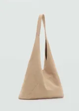 Bolso tipo hobo de piel de serraje, con diseño triangular y asa larga integrada. Cuenta con cierre de botón magnético y forro interior de algodón.