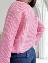 Sweater rosado de punto canalé con cuello redondo y mangas largas. Tejido de punto acanalado.