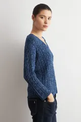 Sweater de tejido de punto con textura acanalada, color verde oscuro, de corte recto y manga larga. Presenta un diseño clásico con cuello redondo.