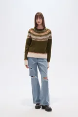 Sweater de poliéster color verde oliva con diseño geométrico en blanco, beige y marrón. Tiene cuello redondo, corte al cuerpo y detalles de cuentas en el cuello.