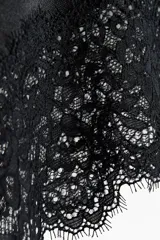 Pollera midi de punto color negro, con cintura elástica y bajo asimétrico decorado con un ribete de encaje.
