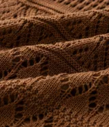Pollera midi de tricot marrón con puntos calados y diseños geométricos, de corte levemente ajustado y cintura con pretina acanalada.