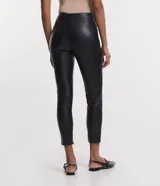 Pantalón tipo legging de mujer, color crema claro, confeccionado en poliuretano (PU) con un diseño liso. Presenta un cierre frontal con botones visibles en la cintura.