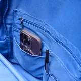 Mochila de tela arrugada color azul, con múltiples compartimentos con cierre, bolsillos laterales y logo circular grabado en el frente.